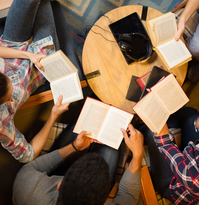 Overhead view of people reading open books