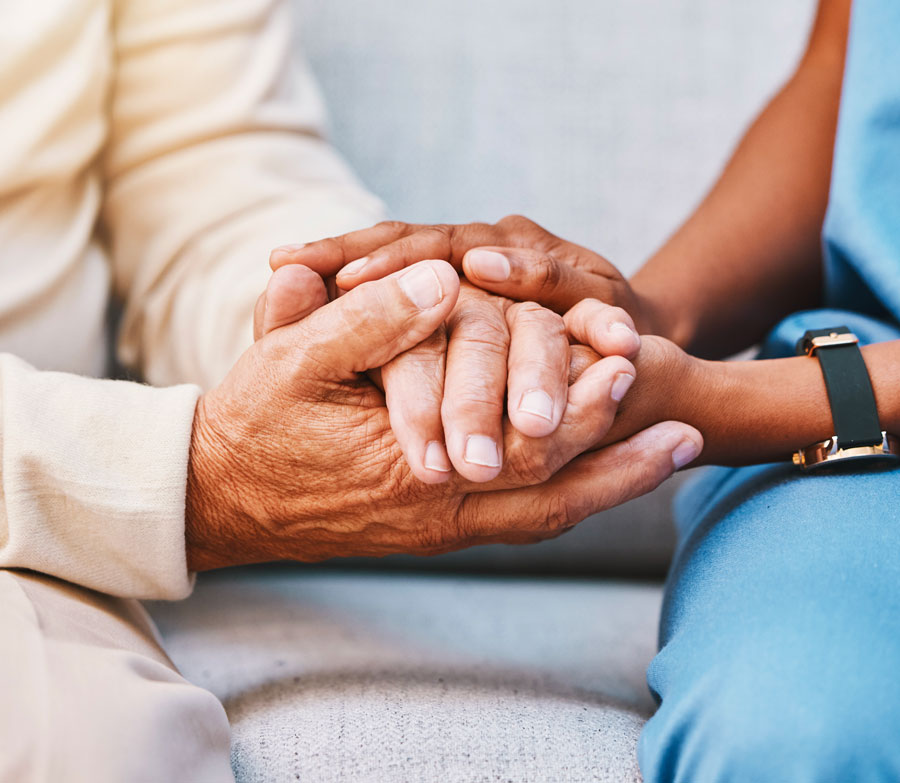 Hands of nurse holding hands of elderly person